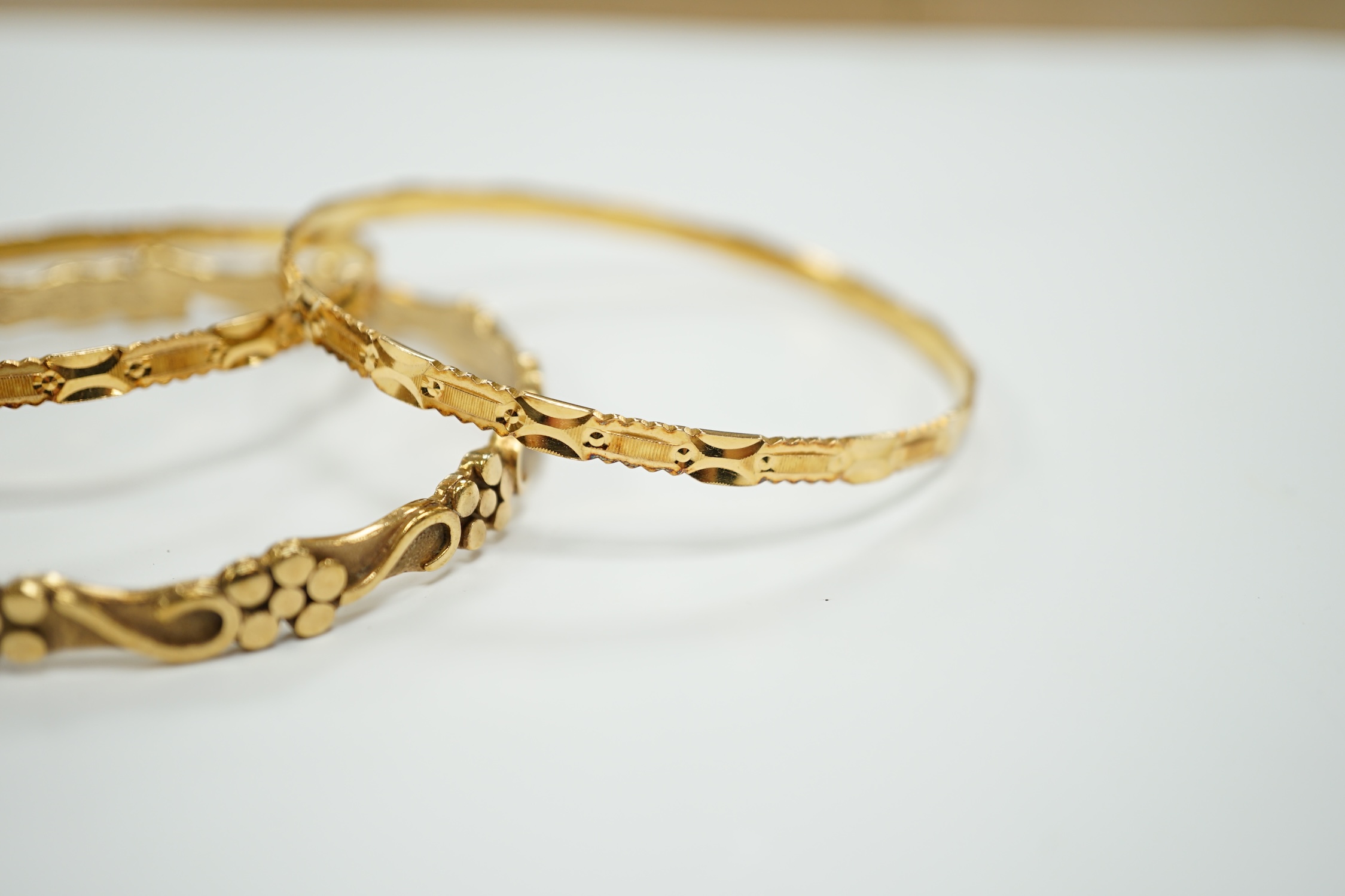 Two 22k bangles, 19.6 grams and a 9ct gold bangle, 20.6 grams.